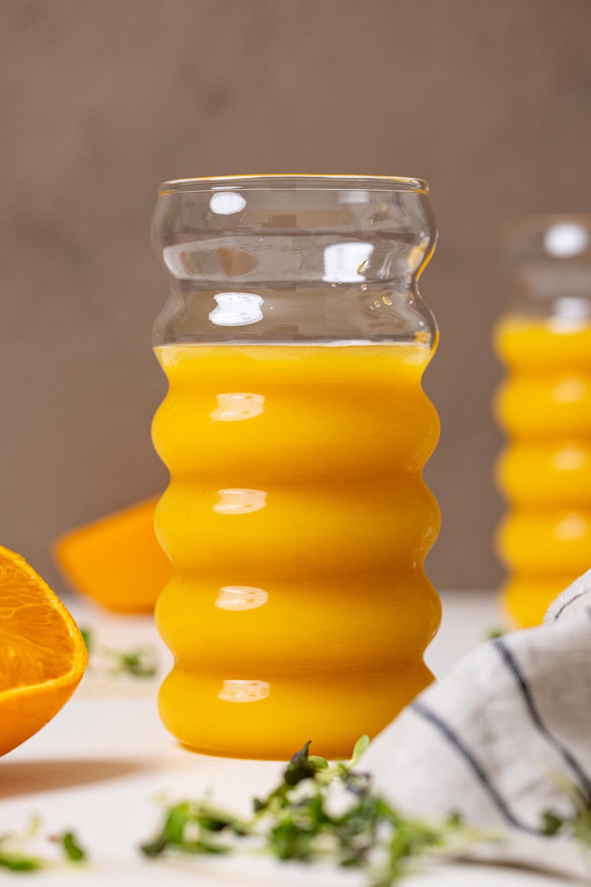 Fresh orange juice in a glass with sliced oranges.