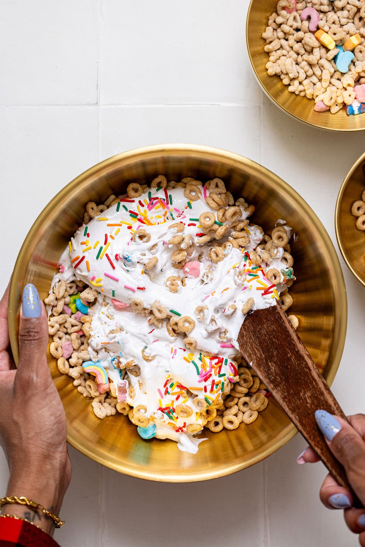 Ingredients being stirred together in a gold bowl with a wooden spoon.