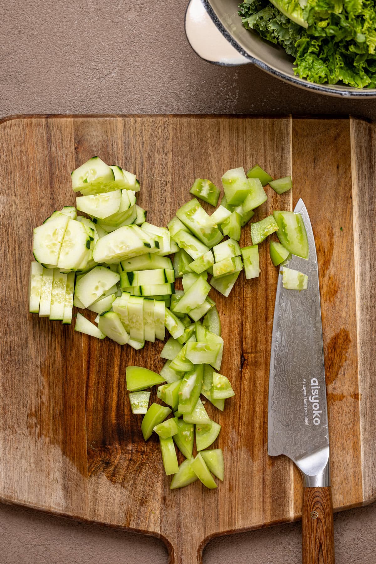 Chopped cucumbers on a cutting board with a knife.