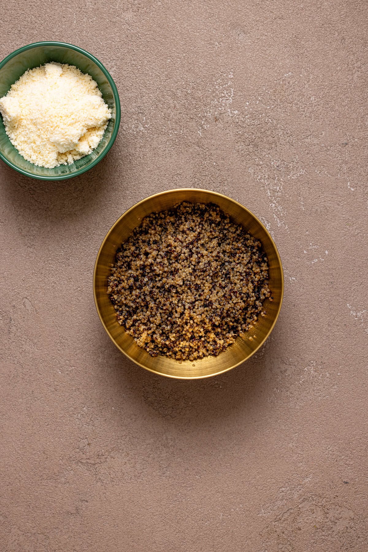 Crunchy quinoa in a gold bowl with grated parmesan.