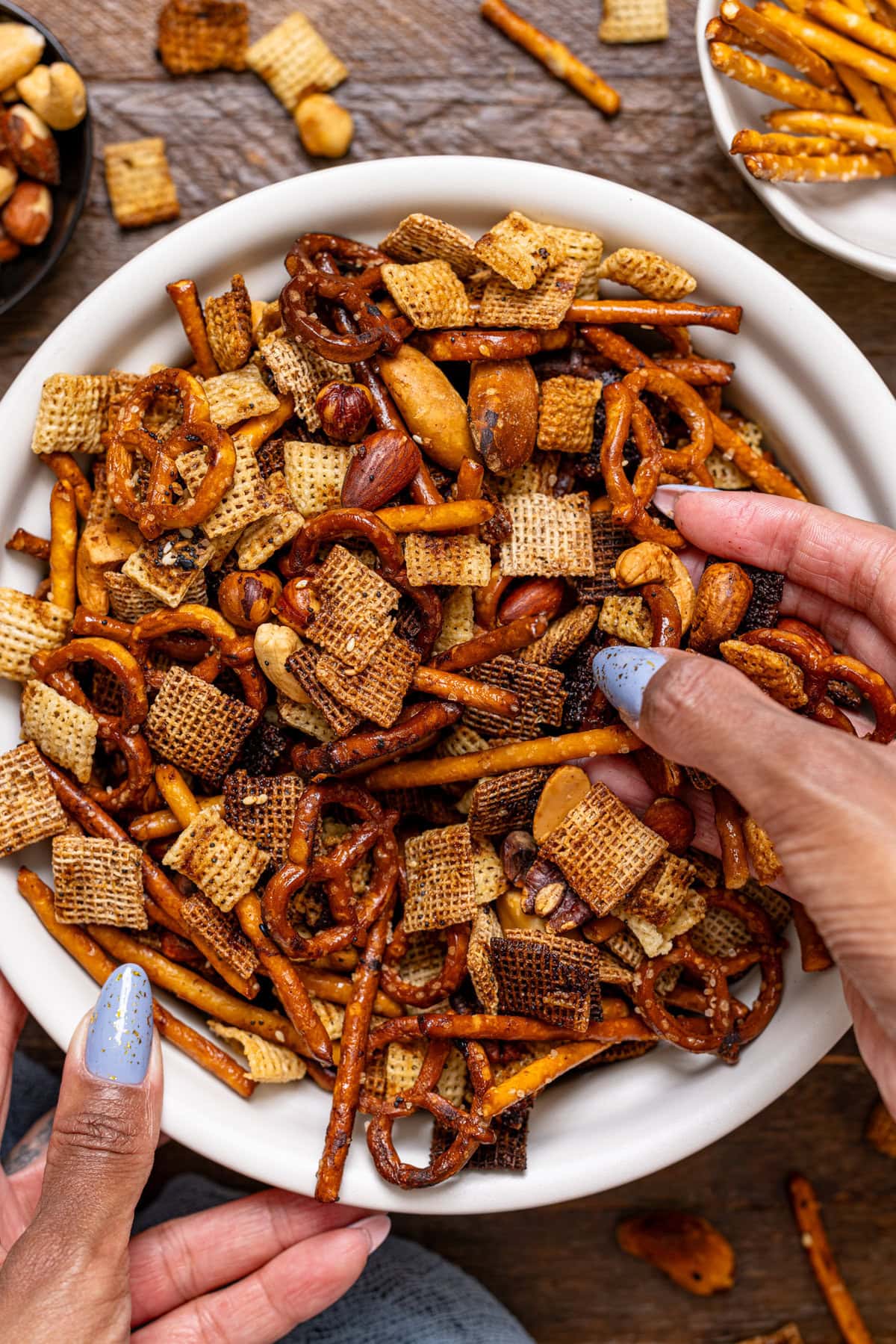 Up close shot of chex mix being held with hands.