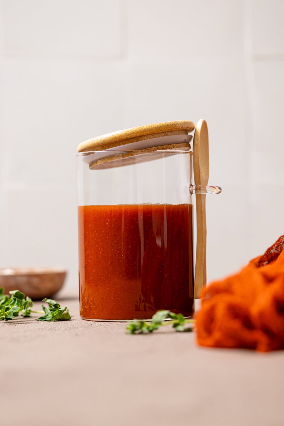 Enchilada sauce in a jar with a wooden spoon.