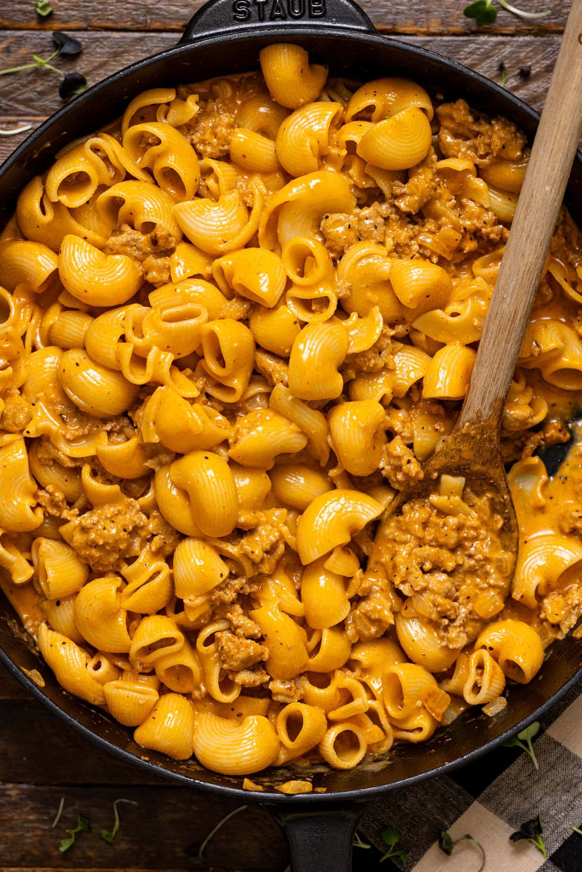 Hamburger Helpers in a black skillet with a wooden spoon.