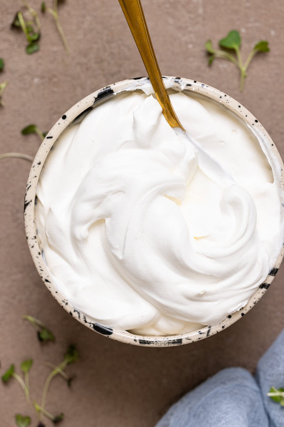 Whipped cream in a bowl with a spoon. 