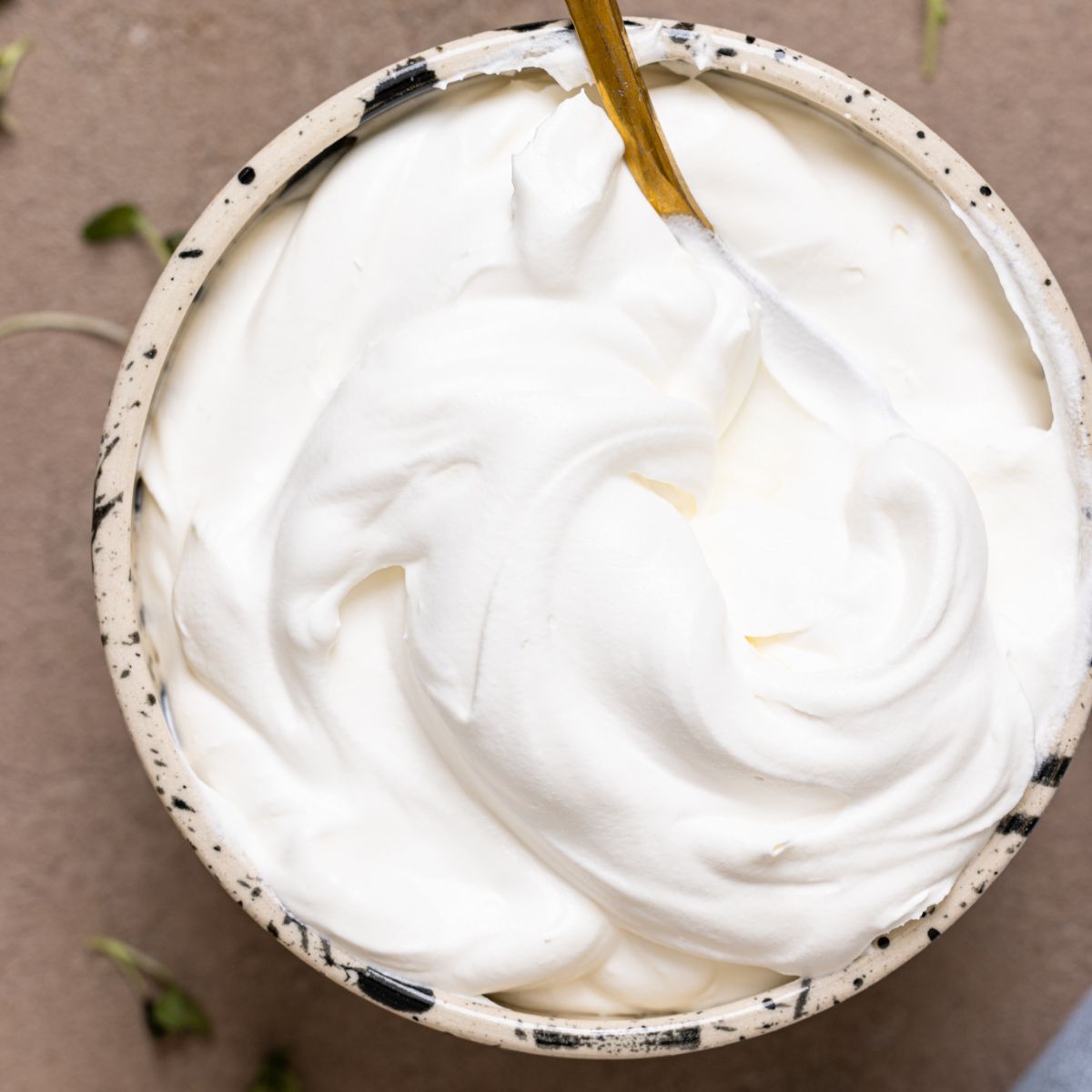 Whipped cream in a bowl with a spoon.