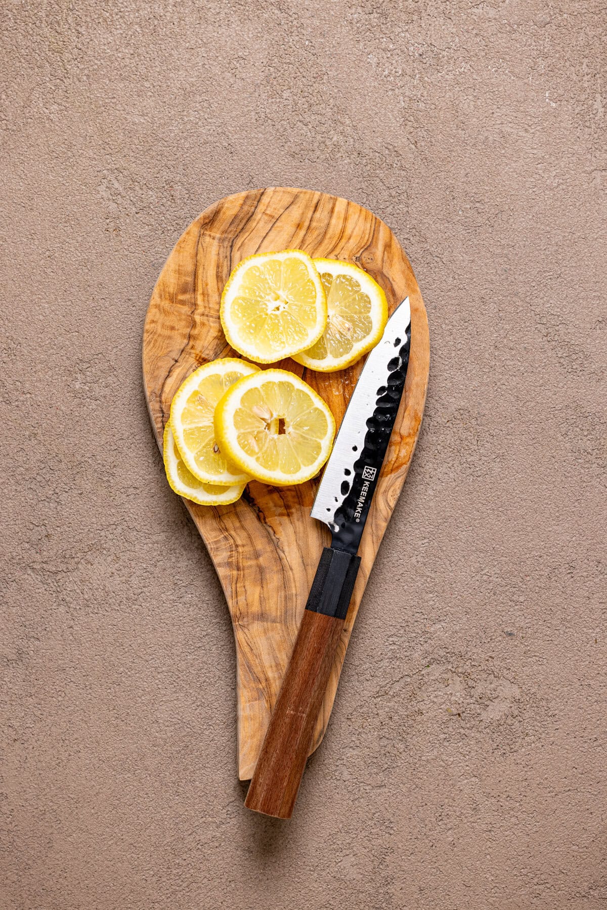 Lemon slices on a cutting board with a knife. 