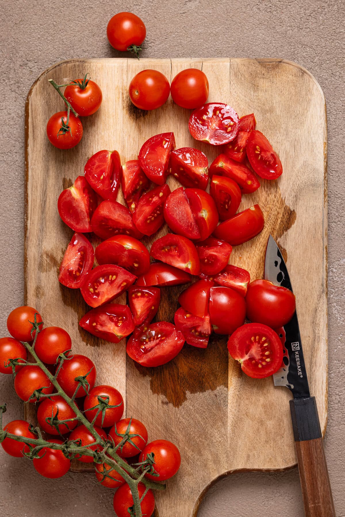 Chopped tomatoes on a cutting board with a knife.