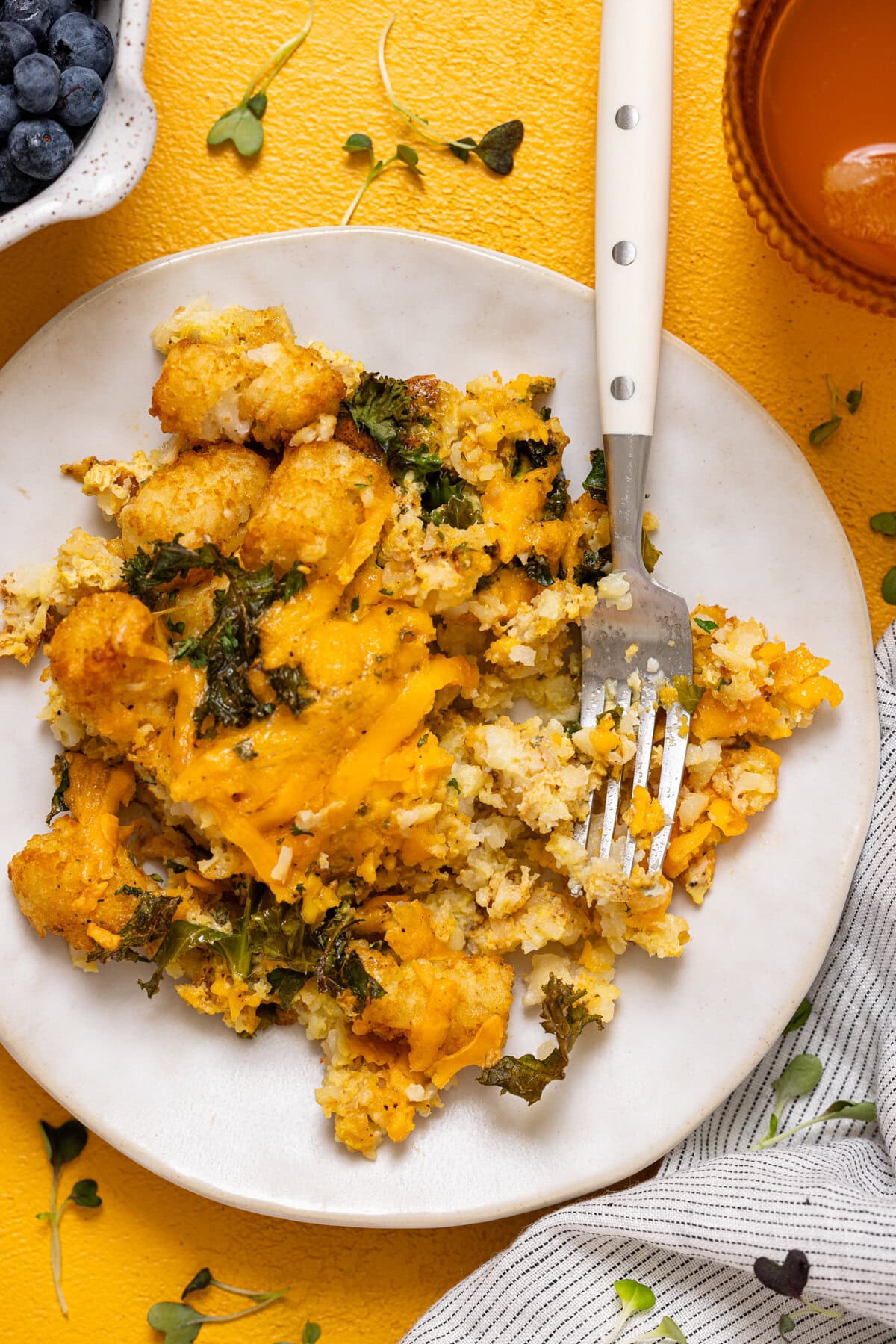 Up close shot of plate with baked tater tot casserole with a fork.