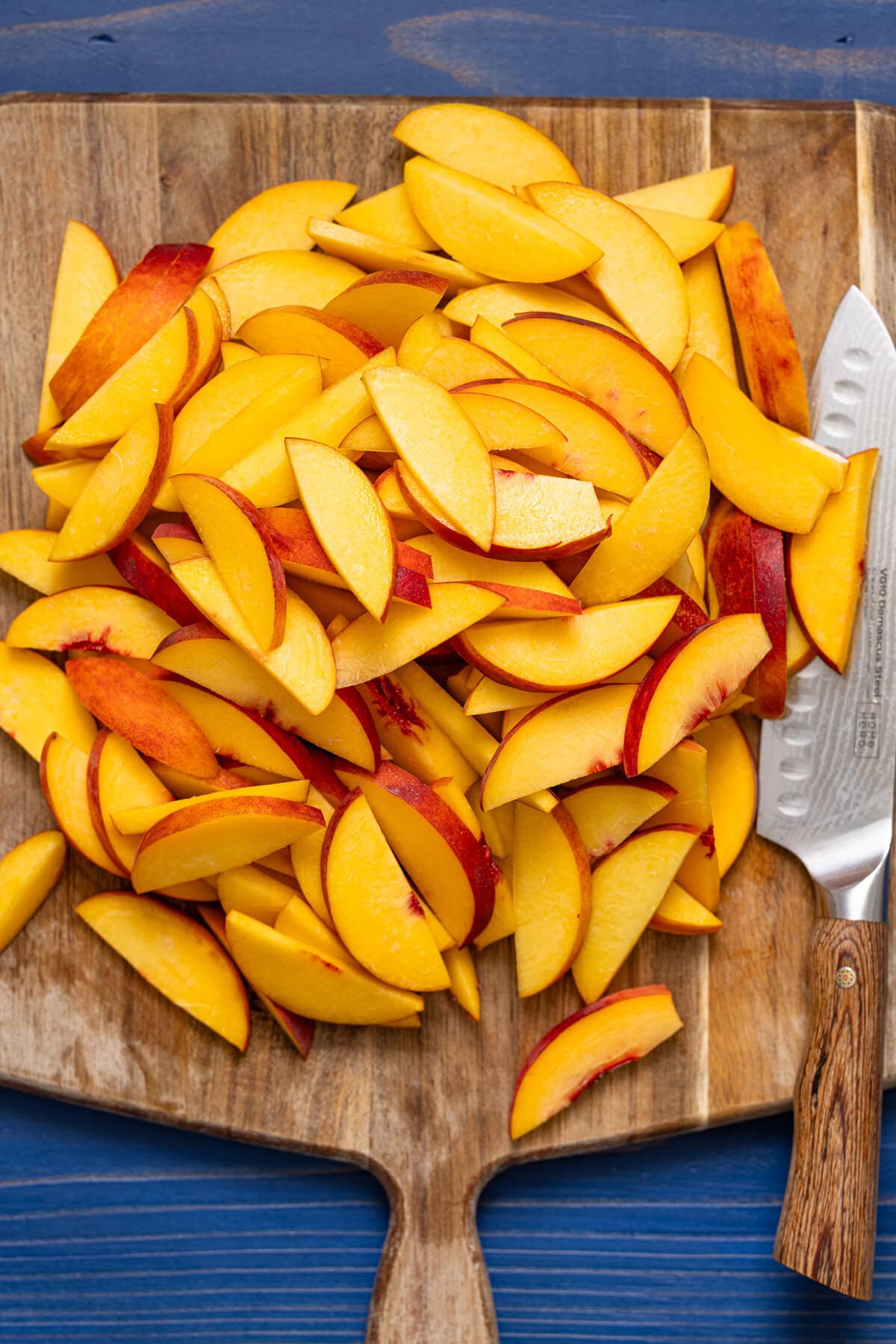 Sliced peaches on a cutting board with a knife.