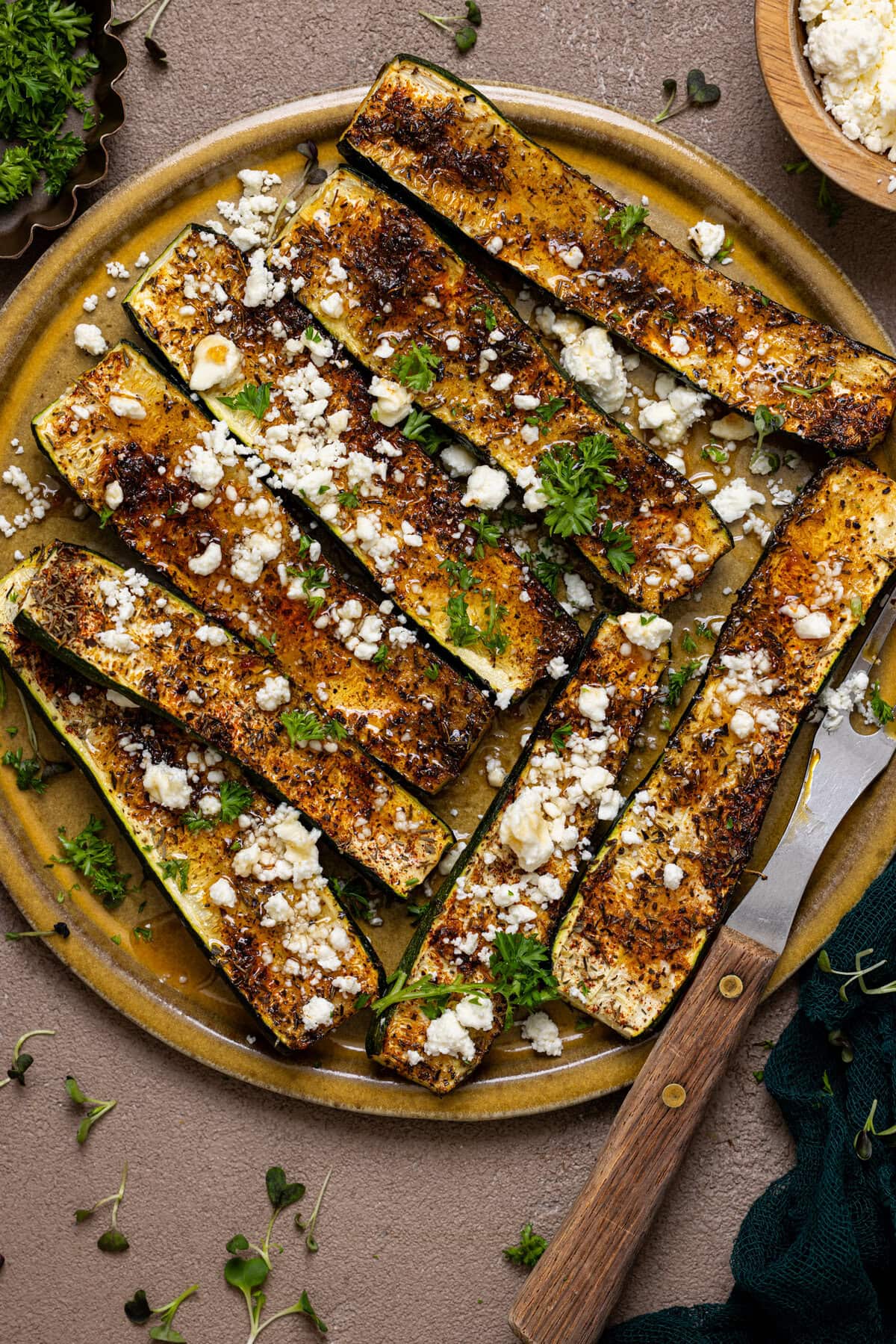 Roasted zucchini on a plate with a fork.