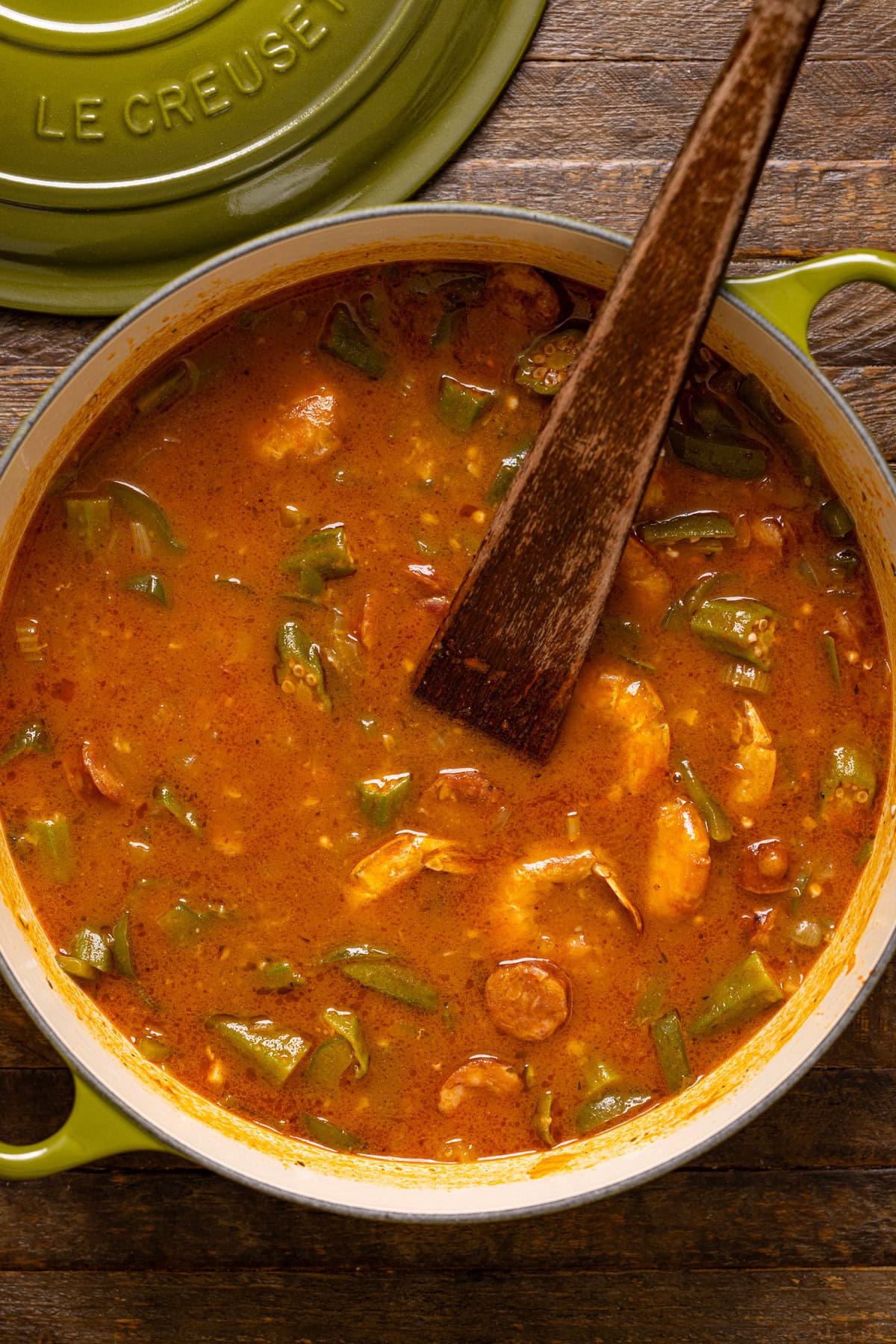 A pot of gumbo with a wooden spoon.