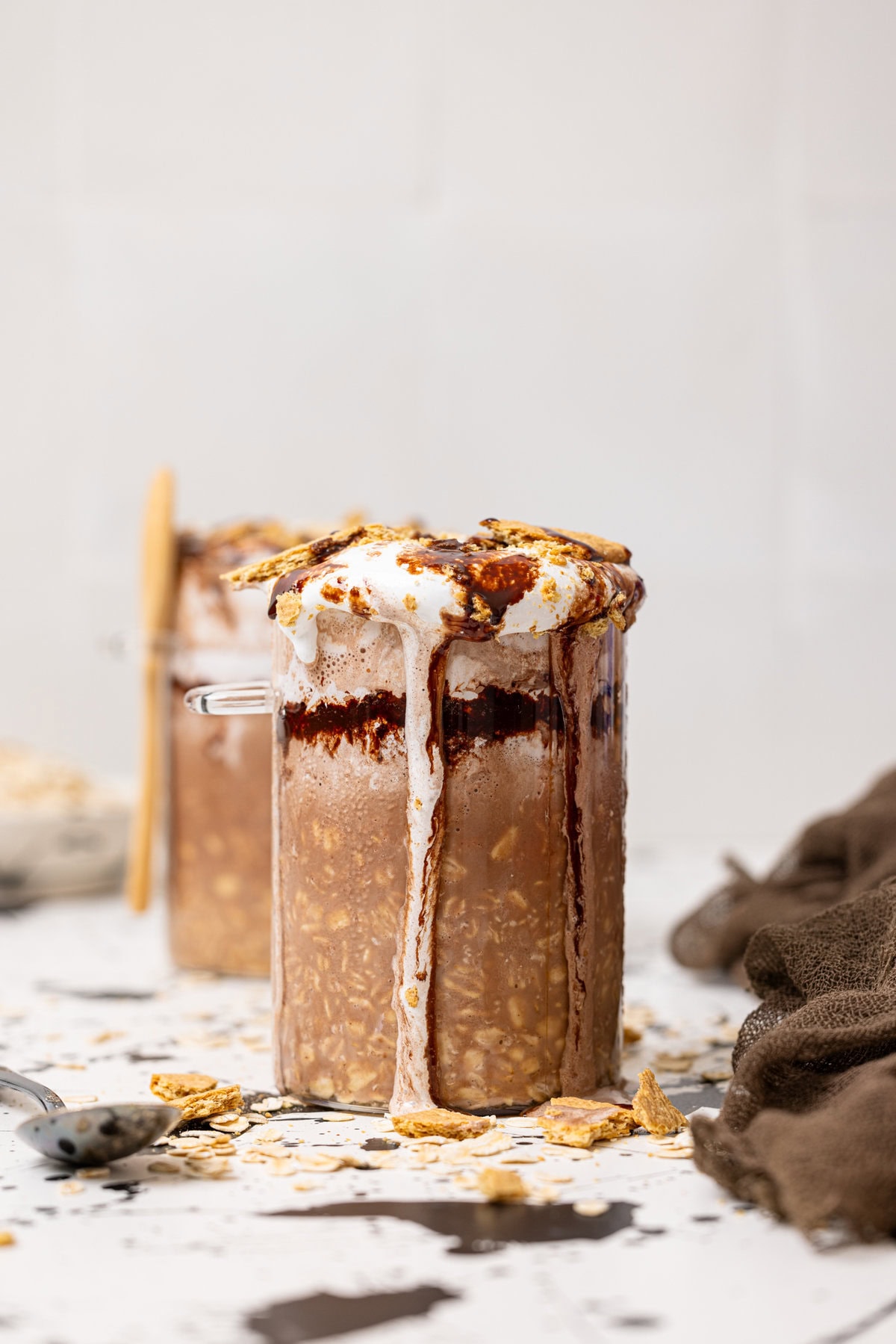 S'mores overnight oats in two jars with a spoon.