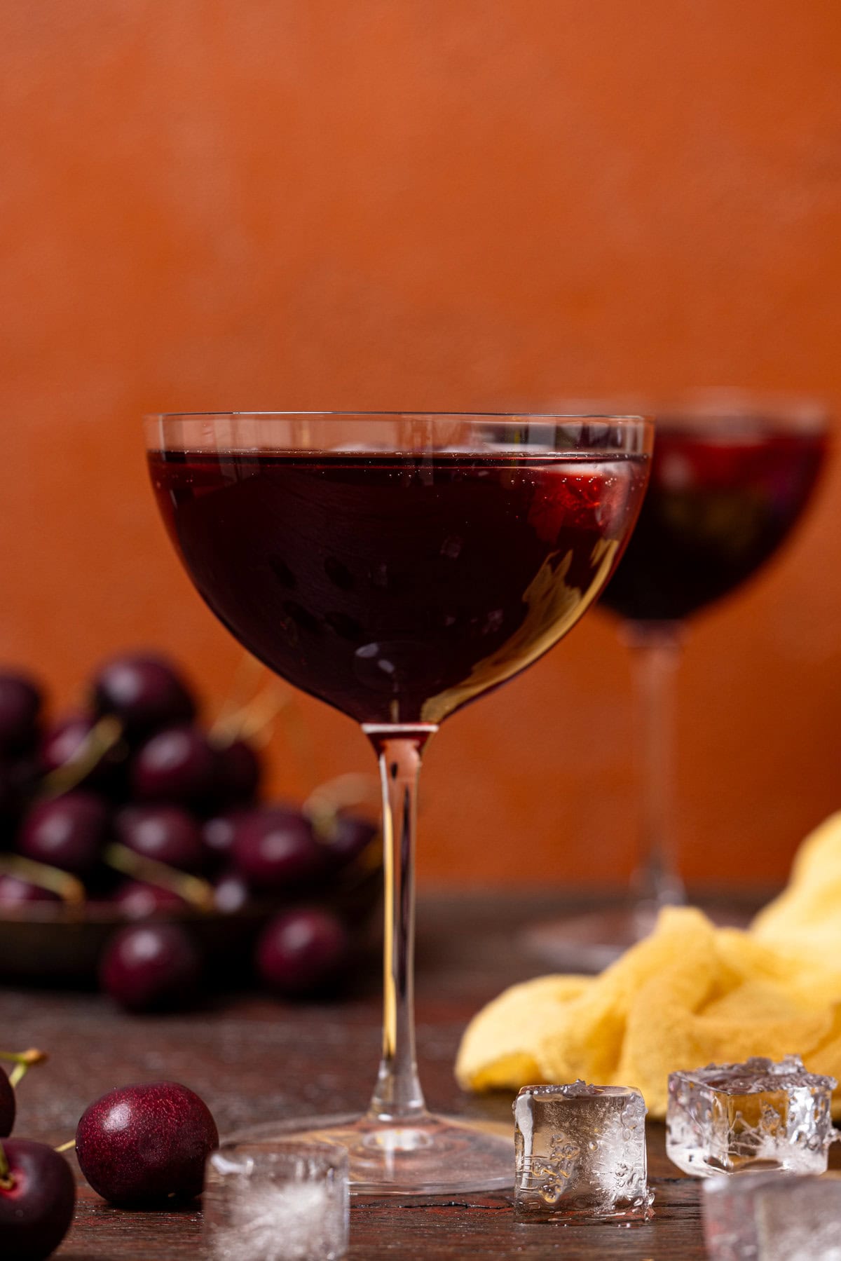 Two stem glasses of sparkling tart cherry drinks with cherries.