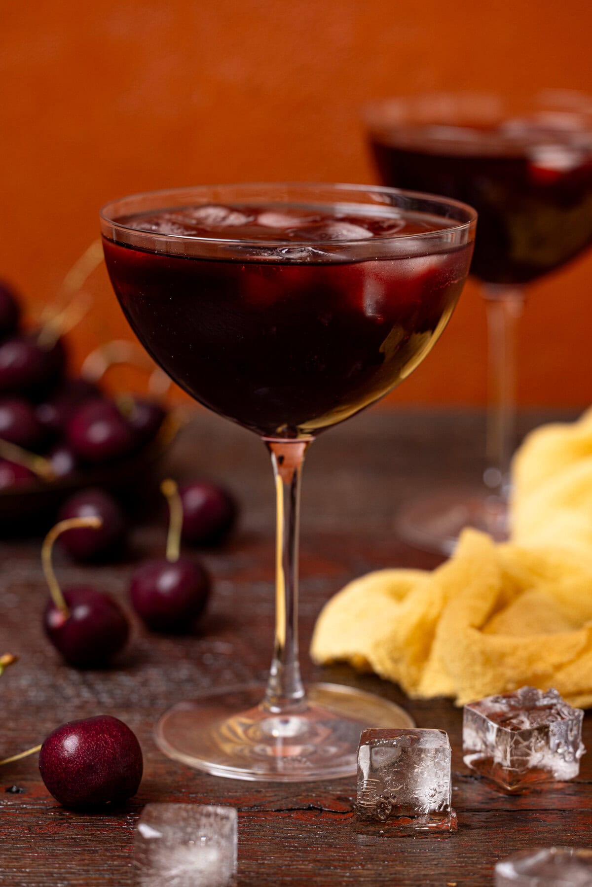 Tart cherry drink in two martini glasses with cherries.