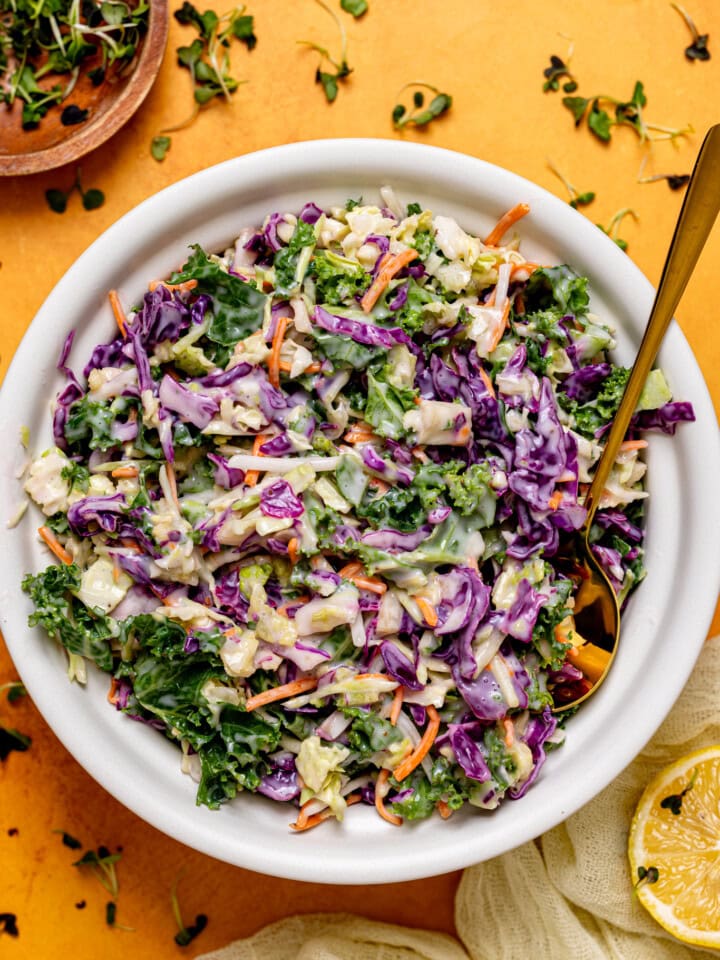 Coleslaw in a bowl with a spoon.