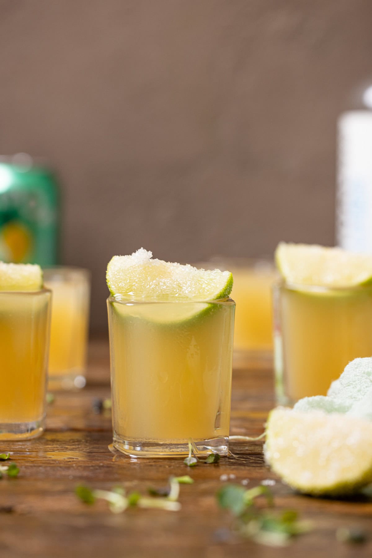 Green tea shots on a brown wood table.