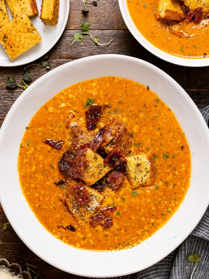 Up close shot of tomato bisque topped with grilled cheese croutons.