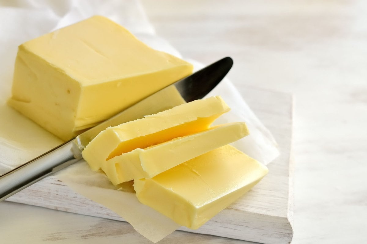 Butter being sliced with a knife.