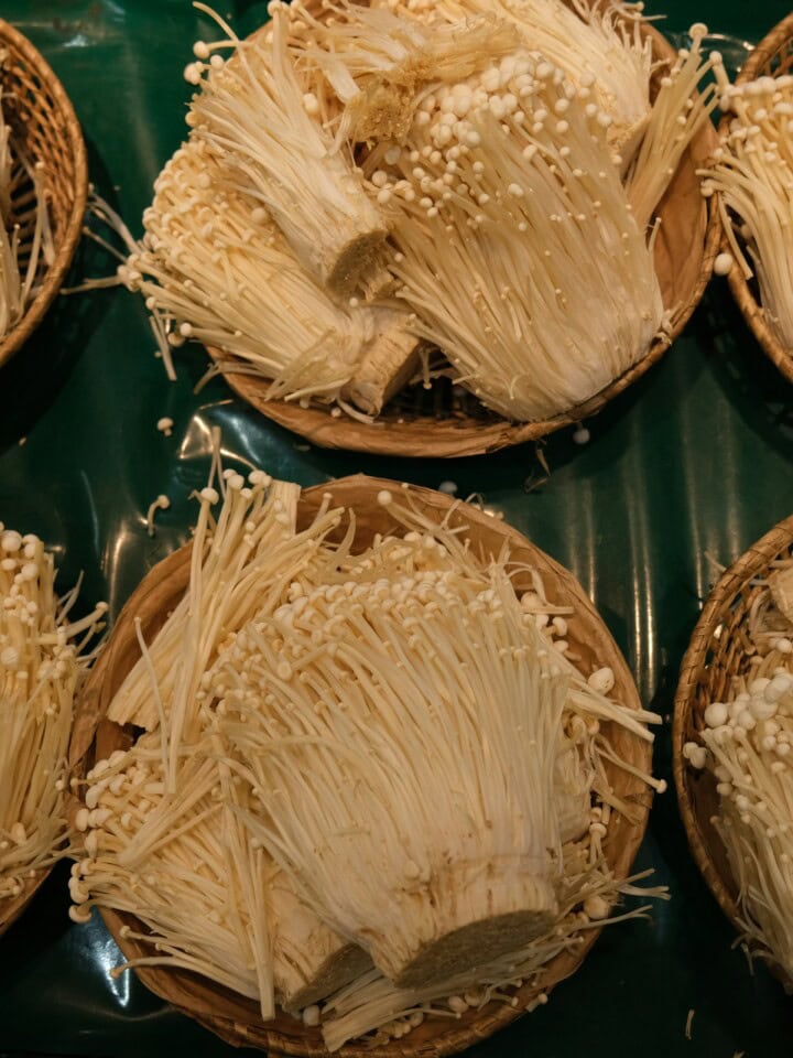 Enoki mushrooms on banana leaf.