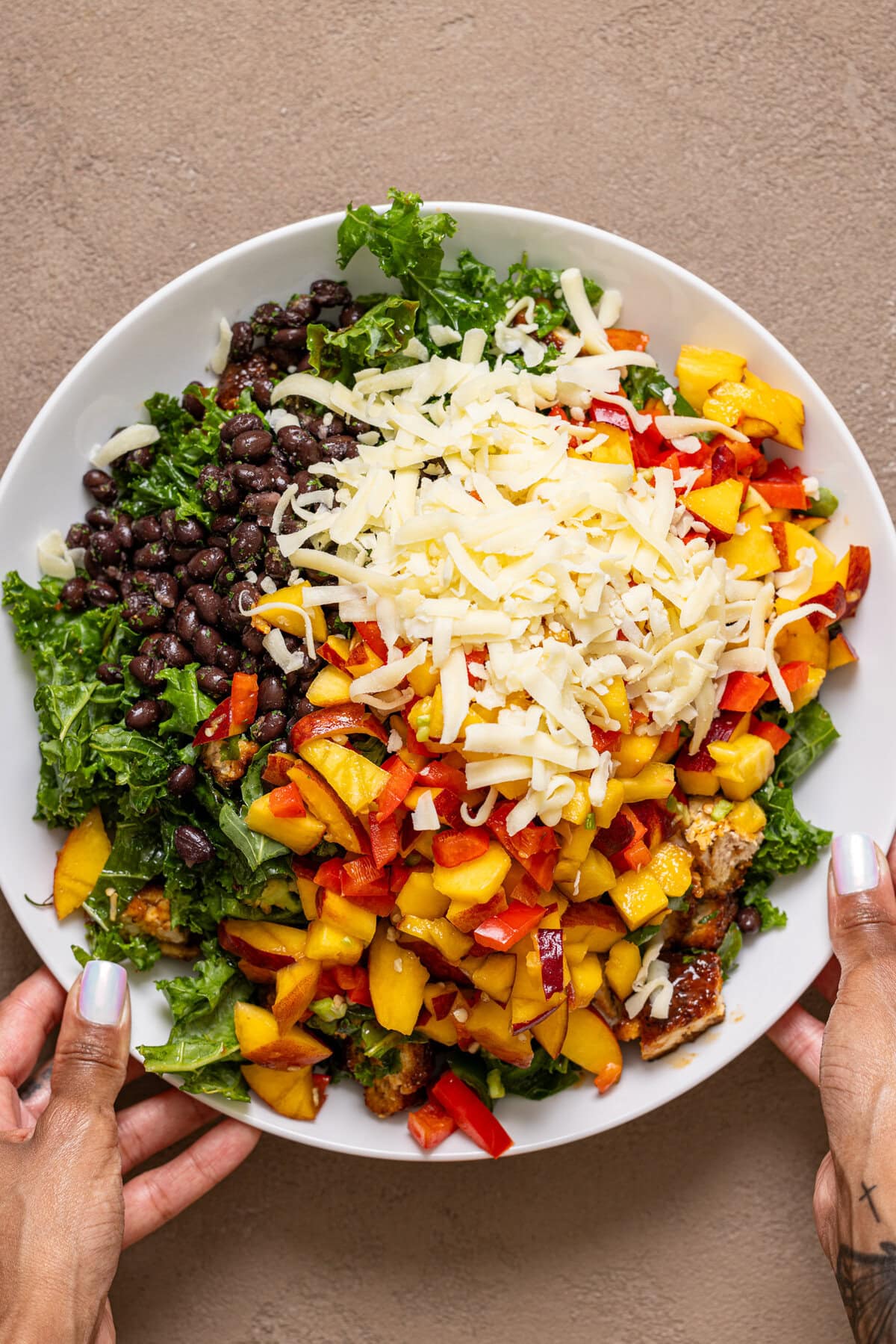 Ingredients in a serving bowl being held with hands.