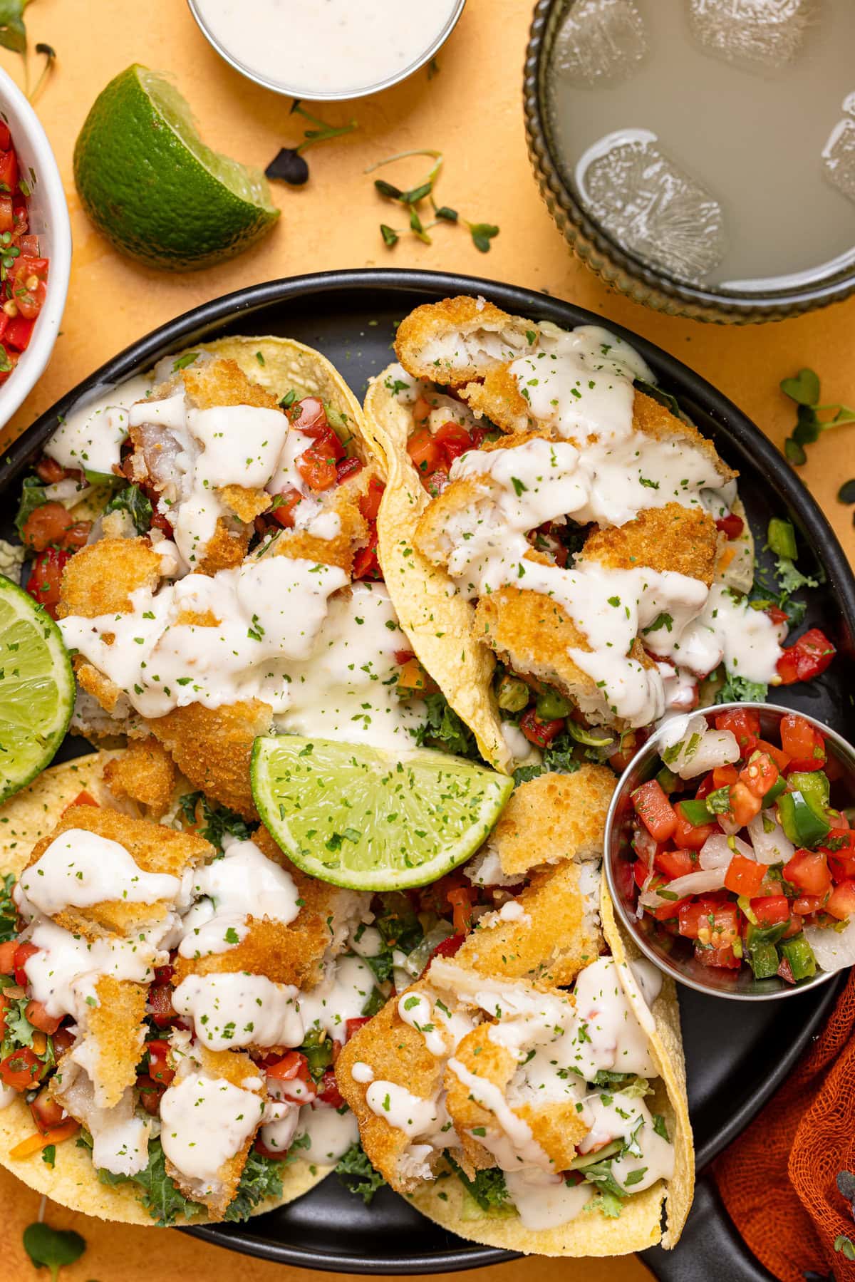 Up close shot of baja tacos on a yellow table.