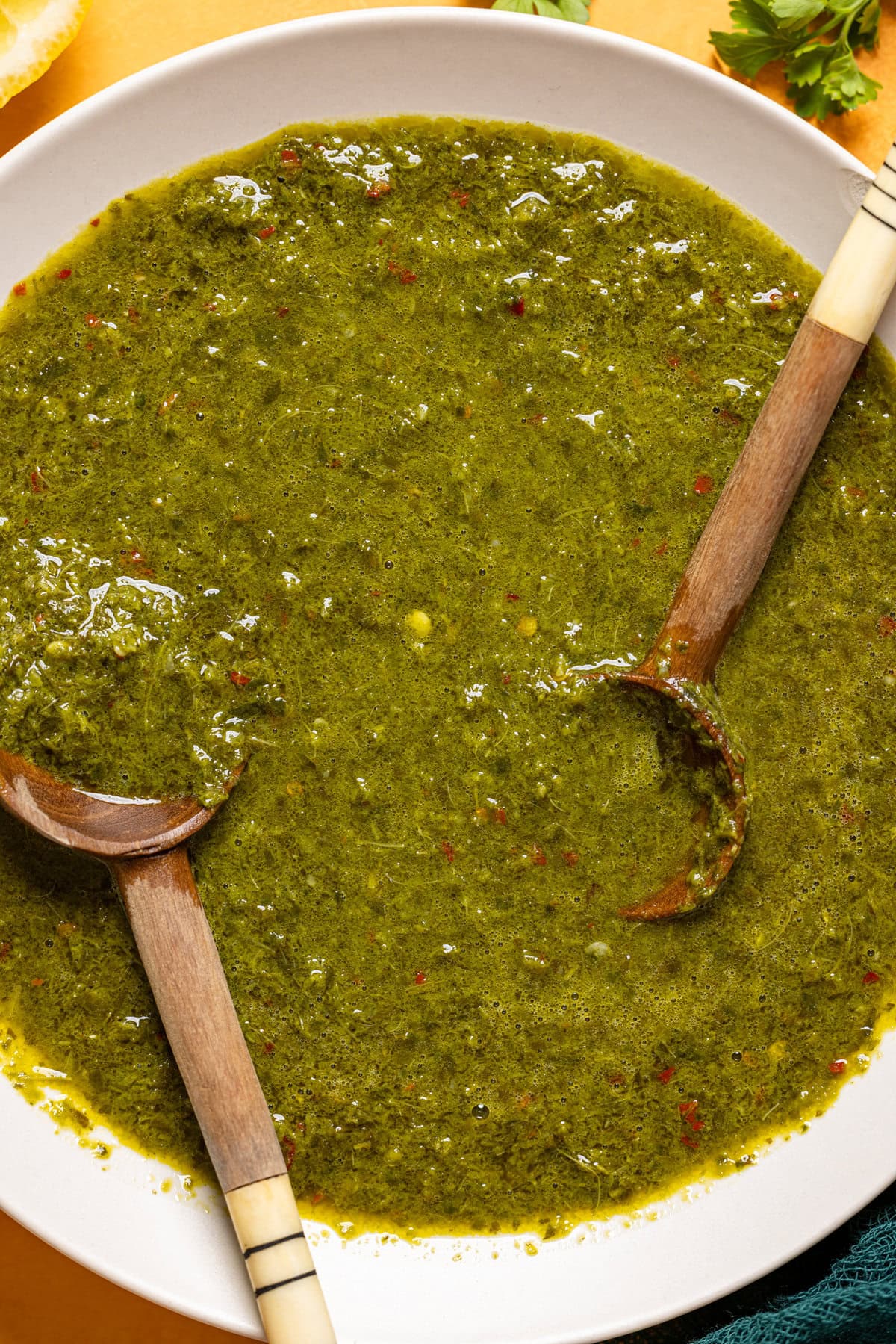 Chimichurri sauce in a bowl with two spoons.