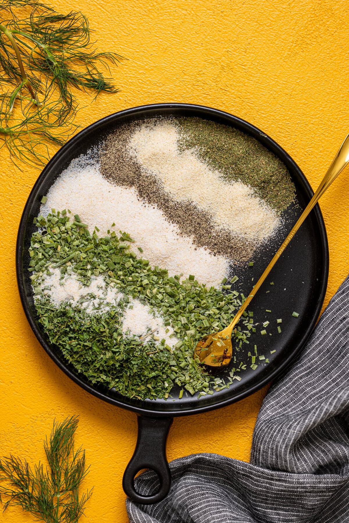 Ranch seasoning mix on a black plate with a spoon.