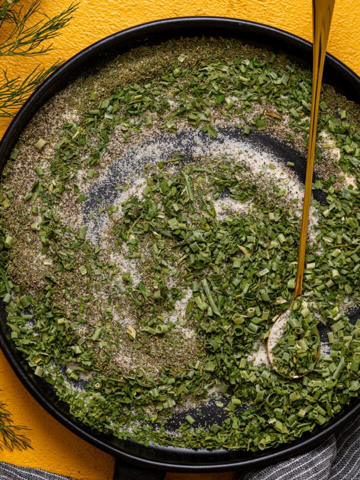 Up close shot of ranch seasoning mix on a black plate with a spoon.