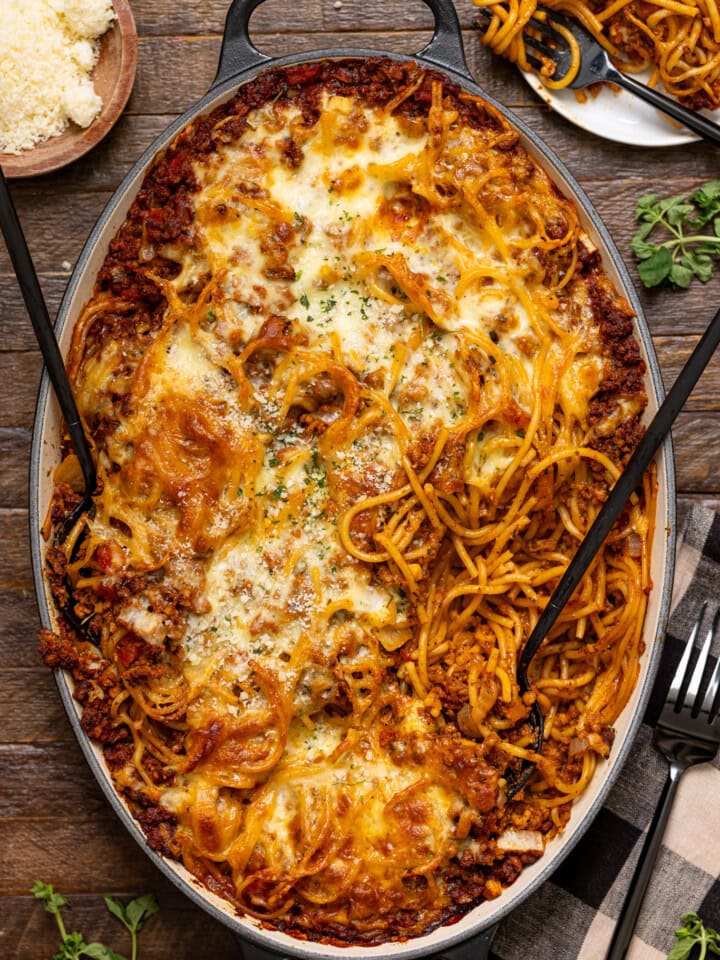 Baked spaghetti with two forks, bread, and forks.