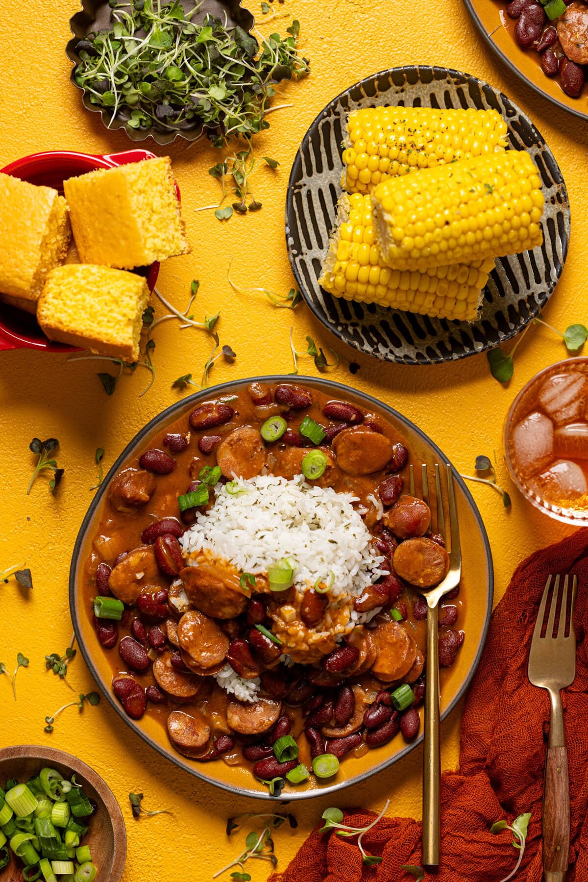 Bowl of red beans + rice in a bowl with ingredients all around. 