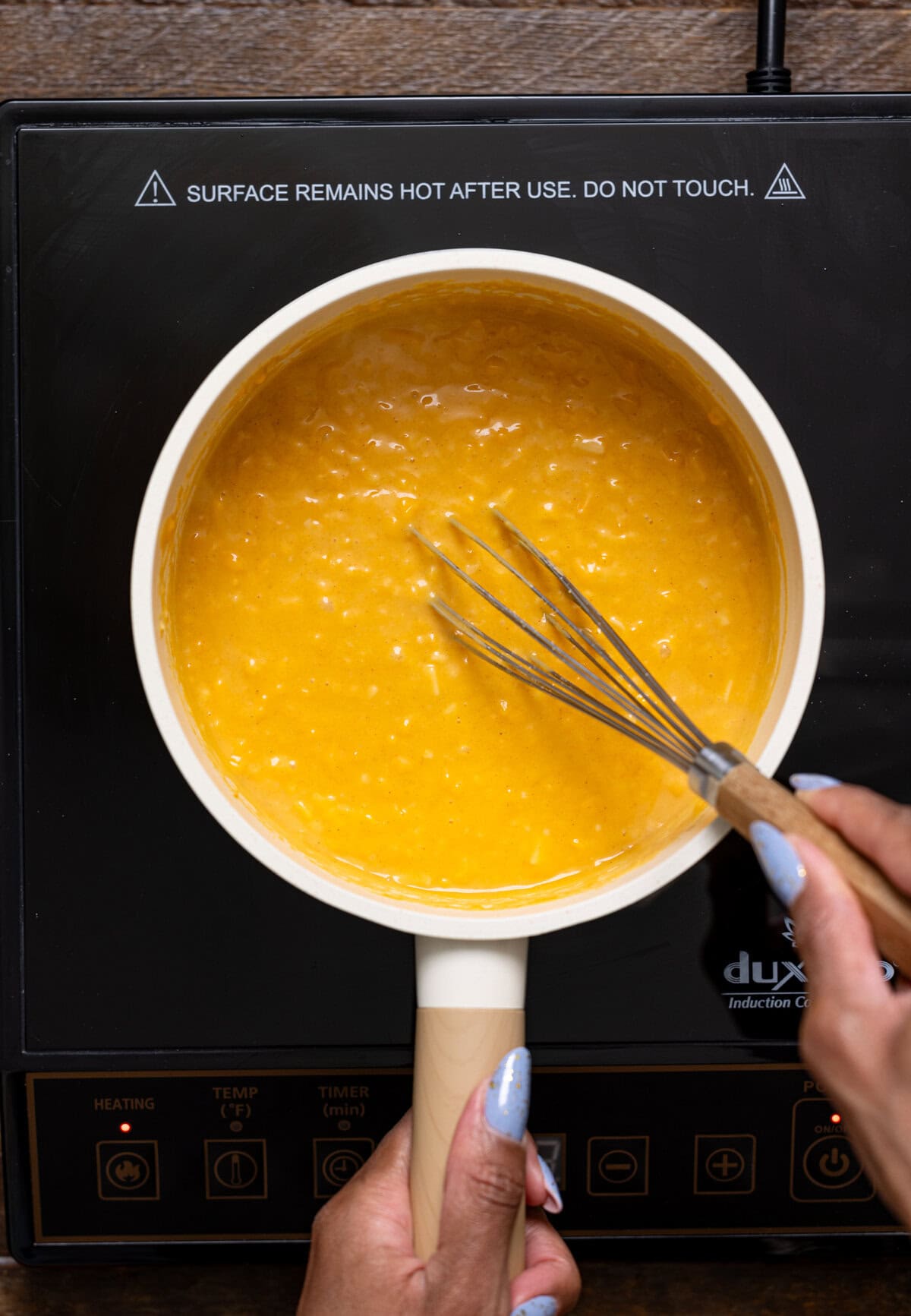 Ingredients being whisked in a pot atop the stove.