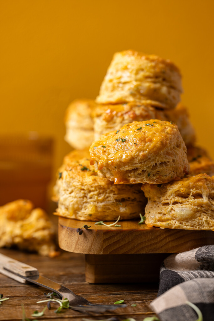 Up close shot of stacked biscuits on a wood platter.