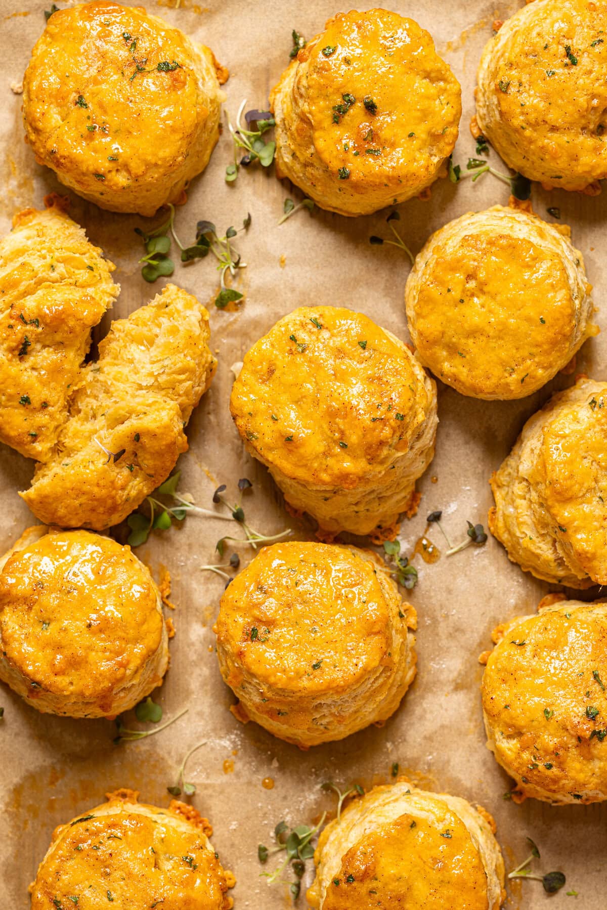 Up close shot of biscuits on a baking sheet with parchment paper. 