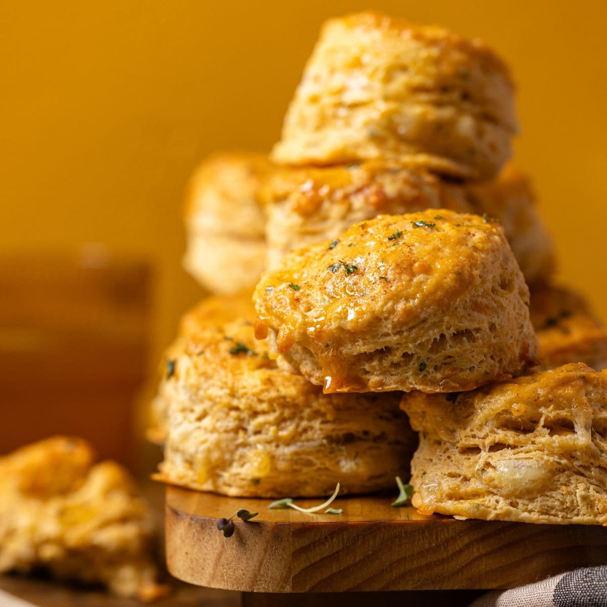 Up close shot of stacked biscuits on a wood platter.