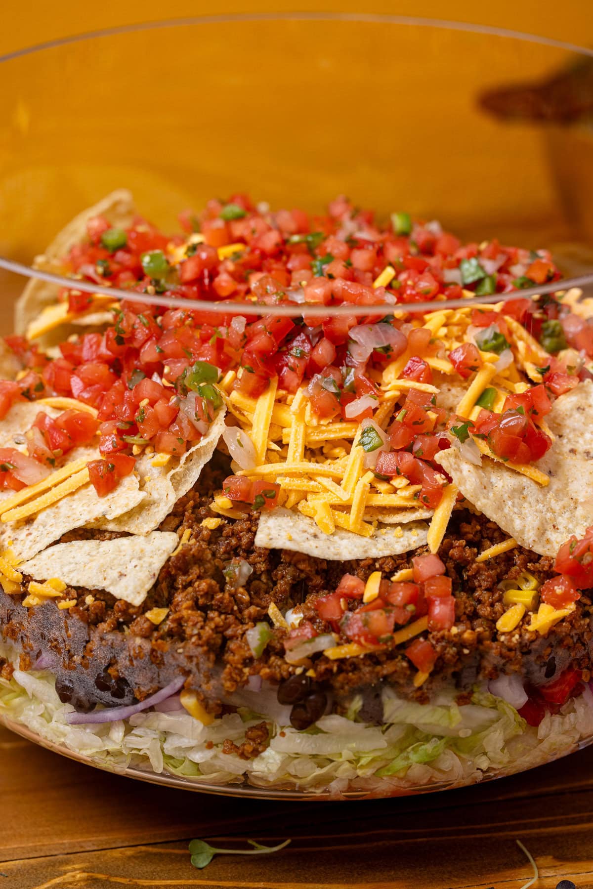 Up close shot of 7-layer taco salad in a trifle dish.