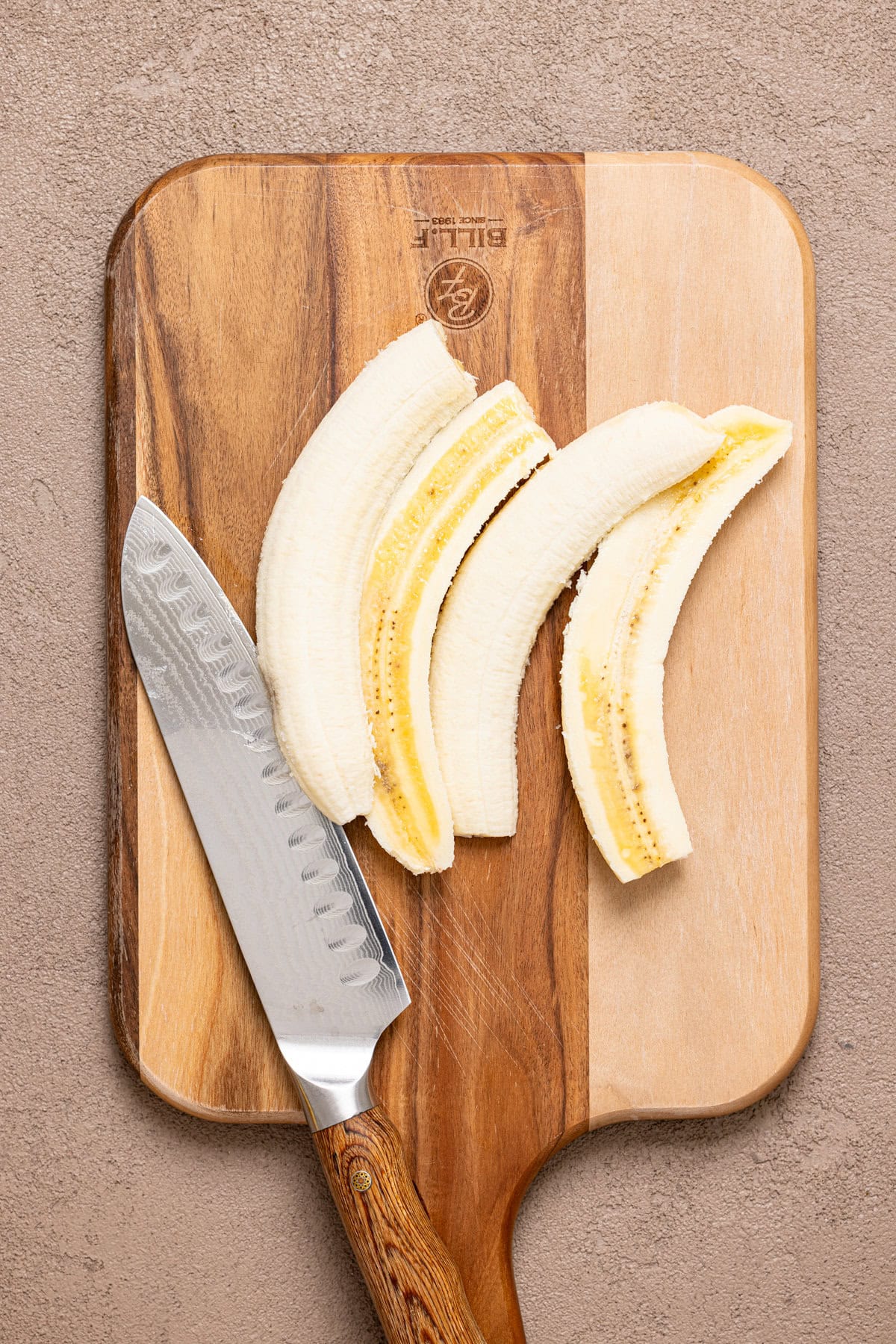 Sliced bananas on a cutting board and a knife.