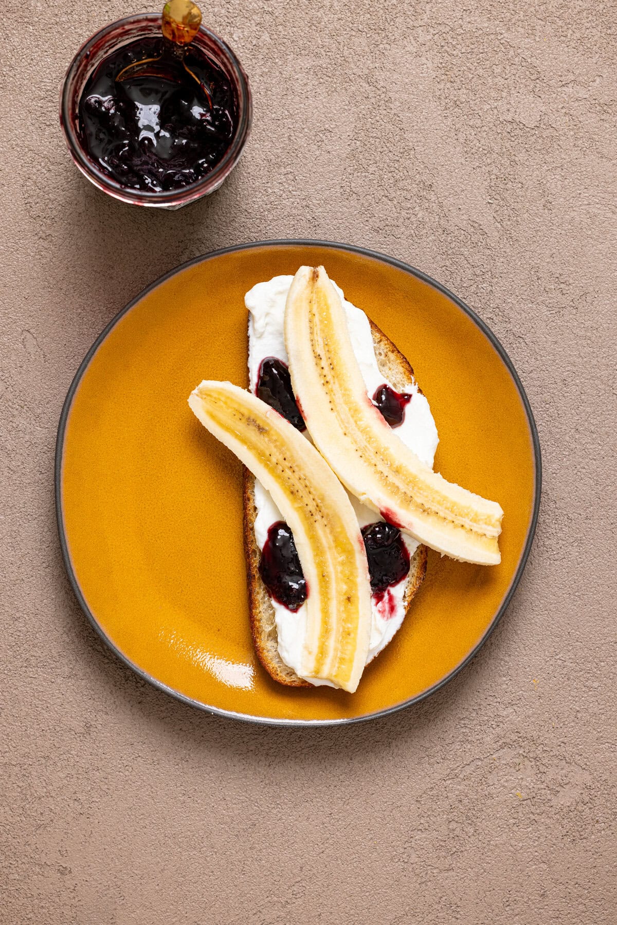 Breakfast toast on a plate with jam and ingredients.