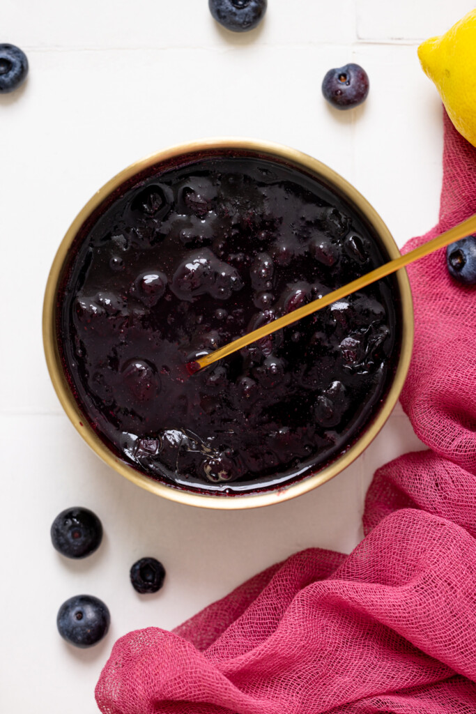 Up close shot of blueberry compote in a bowl with a spoon.