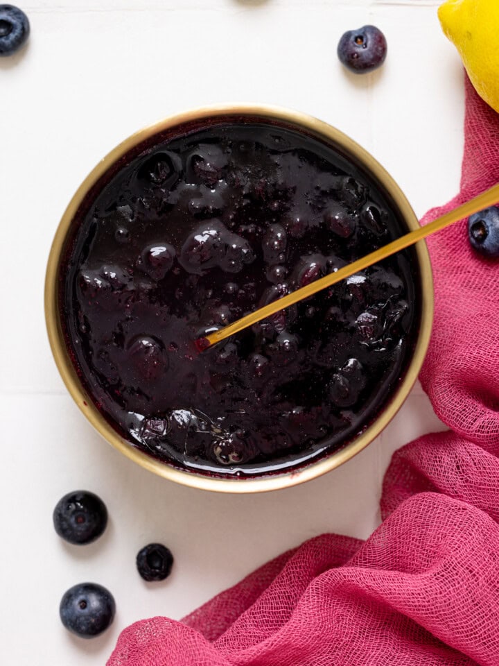 Up close shot of blueberry compote in a bowl with a spoon.