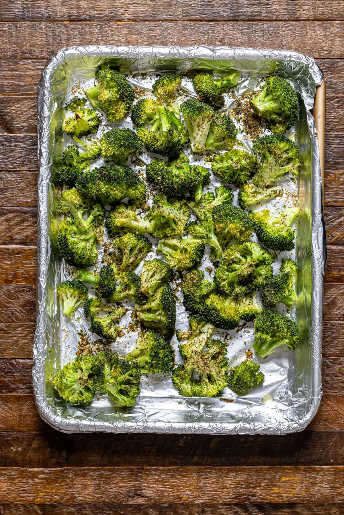 Roasted broccoli on a baking sheet with foil paper.