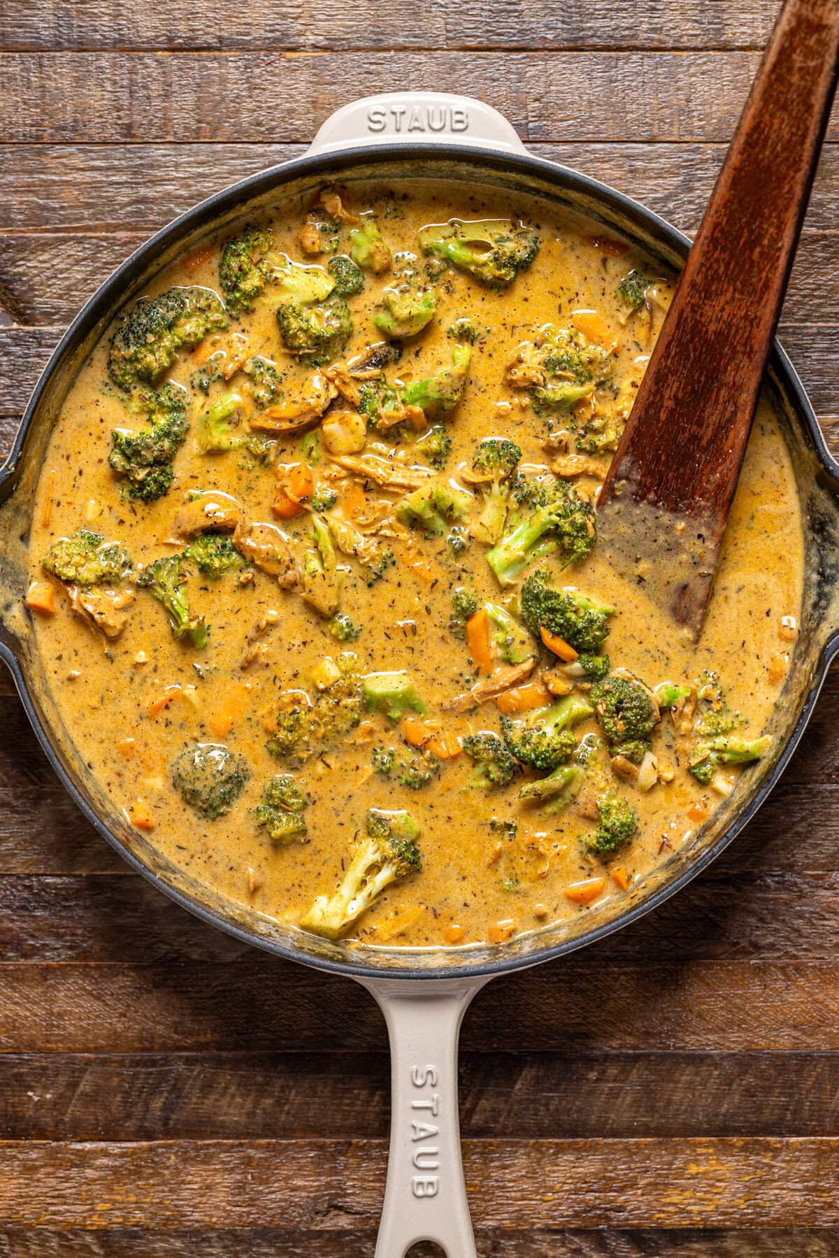 Pot pie filling mixture in a skillet with a wooden spoon.