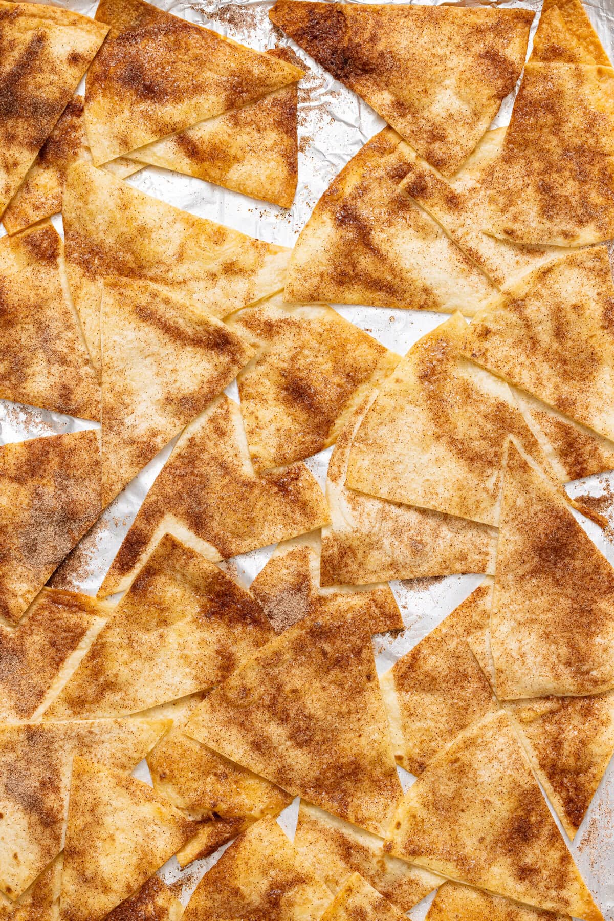 Crispy cinnamon sugar tortilla chips on a baking sheet.