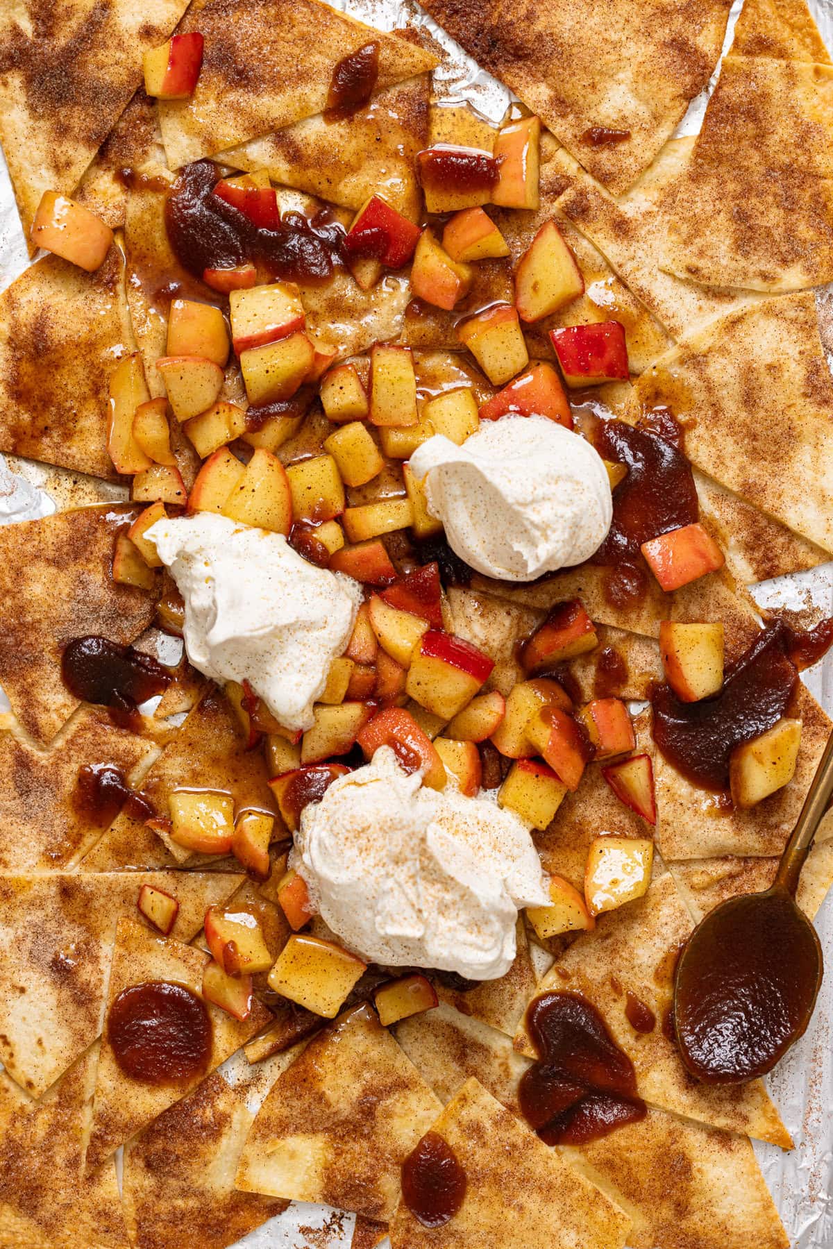 Dessert nachos with whipped cream and a spoon.