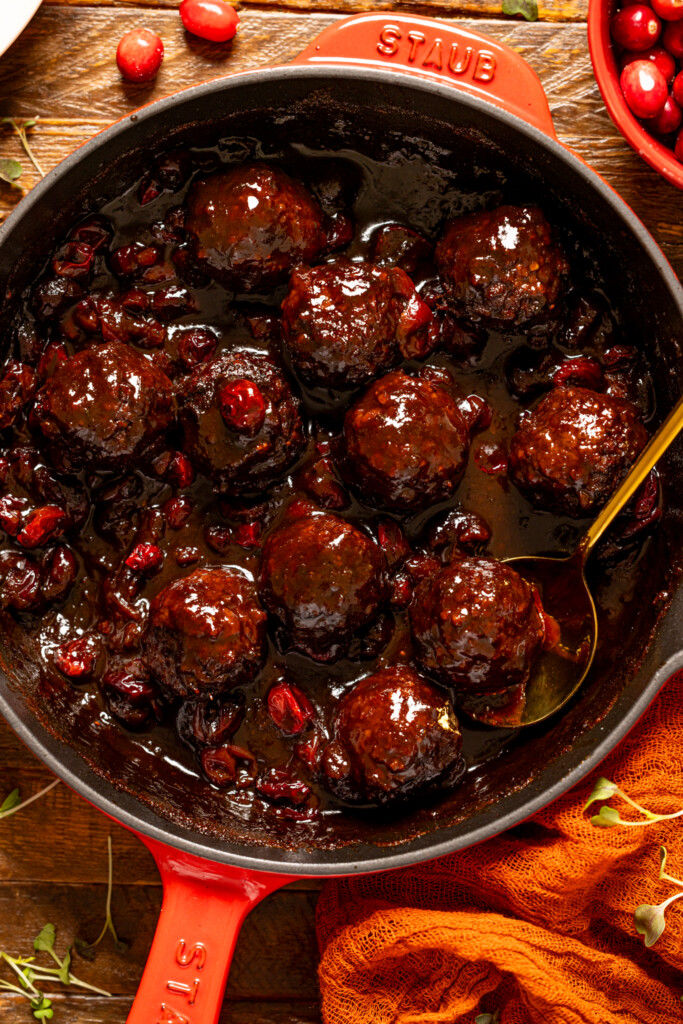 Up close shot of Cranberry BBQ Jerk meatballs with a gold spoon.