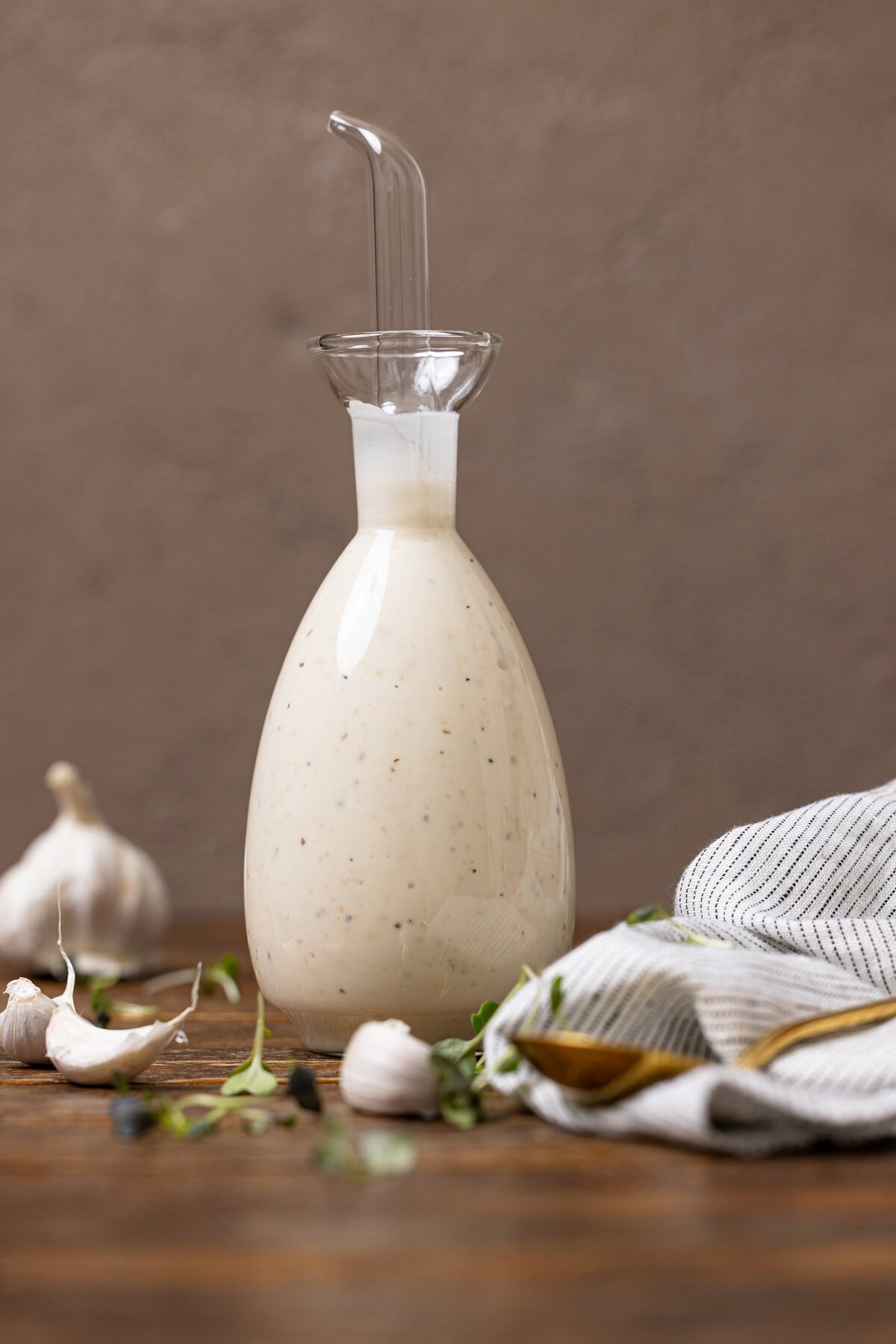 Creamy dressing in a bottle on a brown wood table.