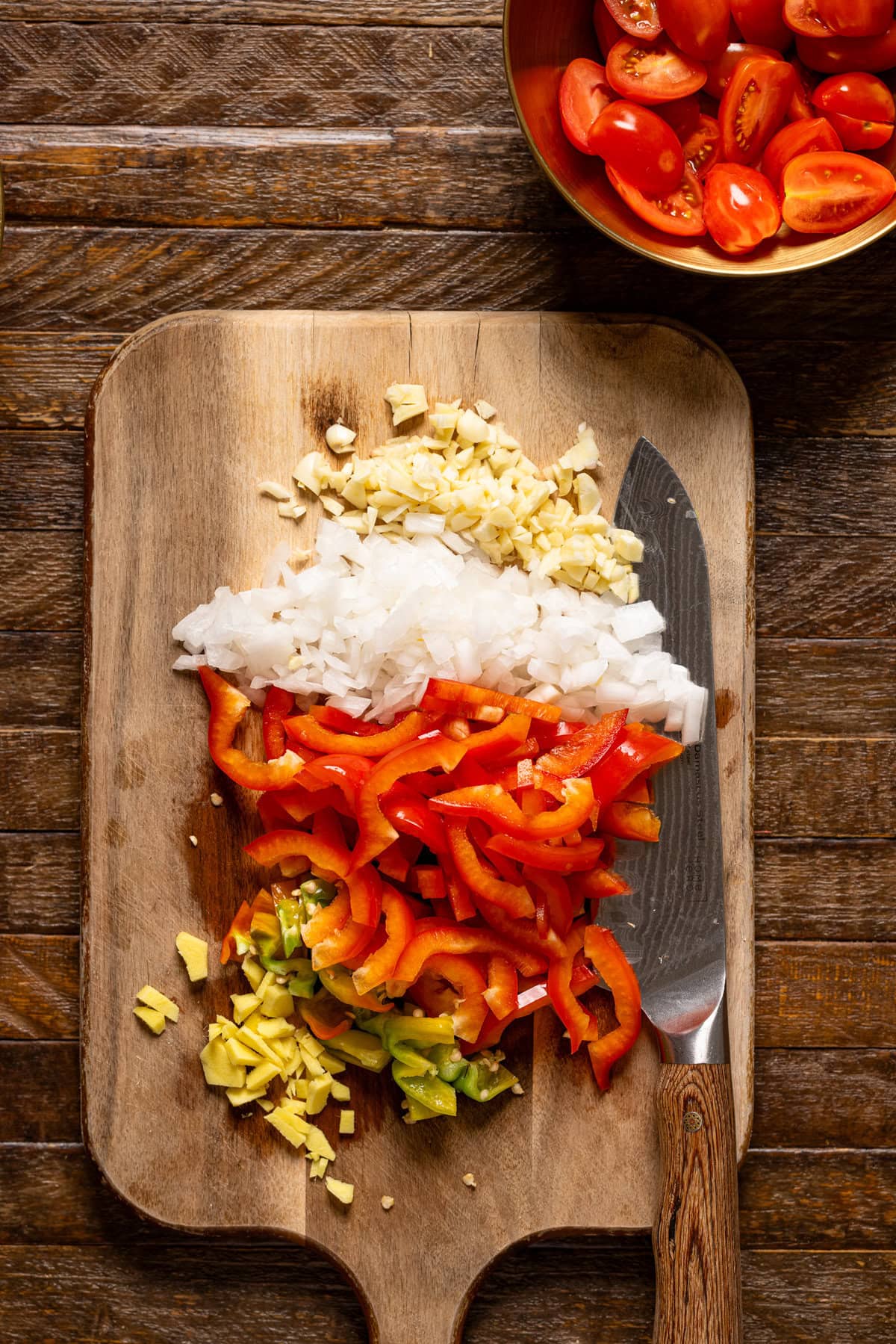 Chopped ingredients on a cutting board with a knife.