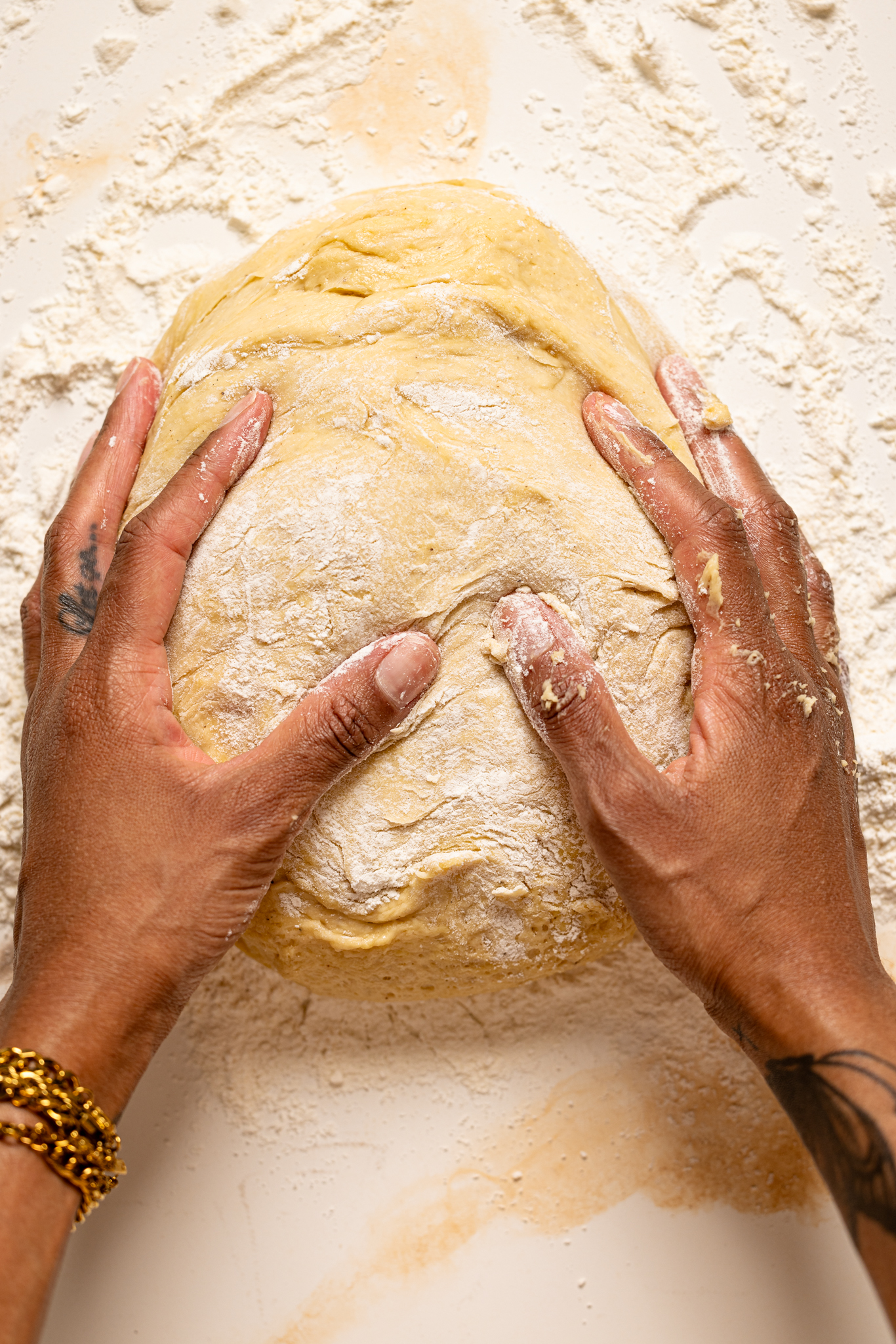 Dough on a floured table being held.